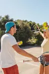 Photo of a loving couple playing tennis together on a tennis court